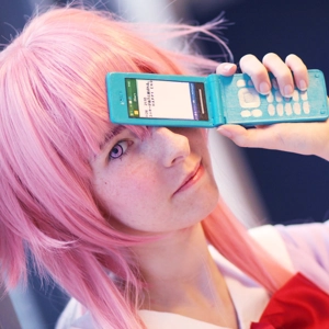 pige med lyserødt hår. med lyserøde øjne. Holder en blå mobil foran sit ene øje.