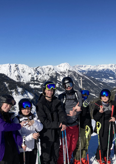 7 unge på ski i Østrig, bjerge med sne i bagrunden
