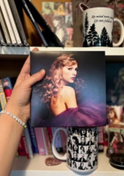 en hånd der holder et billede af Taylor Swift