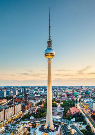 billede af tv-tårnet i Berlin. Højt tårn med en stor kugle næsten i toppen. Blå  og orange himmel  baggrunden.