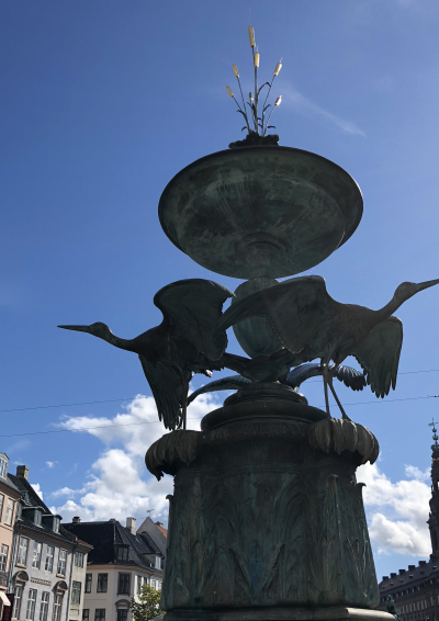 storkespringvandet i København. en skulptur med to storke. blå himmel i baggrunden