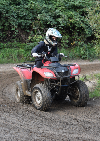 en dreng kører en rød atv på en motorbane