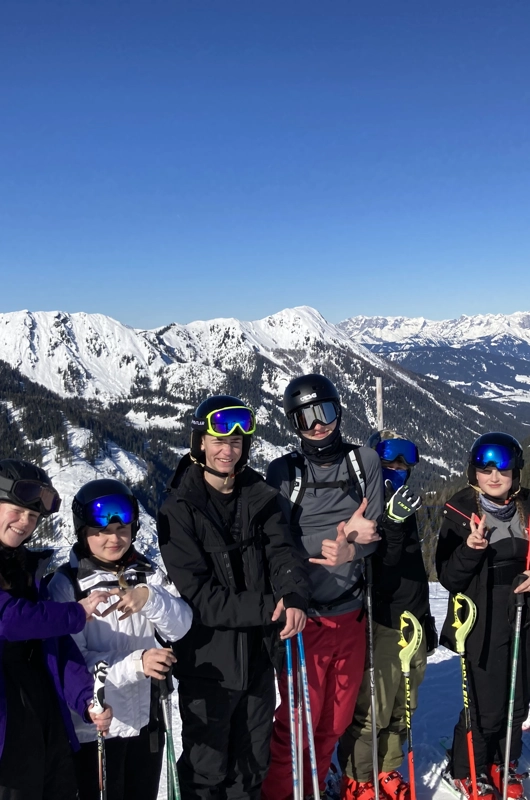 7 unge på ski i Østrig, bjerge med sne i bagrunden