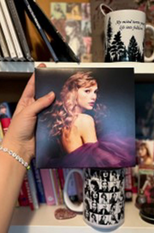 en hånd der holder et billede af Taylor Swift