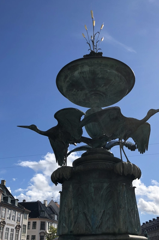 storkespringvandet i København. en skulptur med to storke. blå himmel i baggrunden