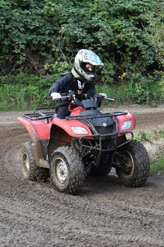 en dreng kører en rød atv på en motorbane