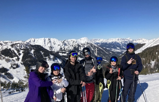 7 unge på ski i Østrig, bjerge med sne i bagrunden